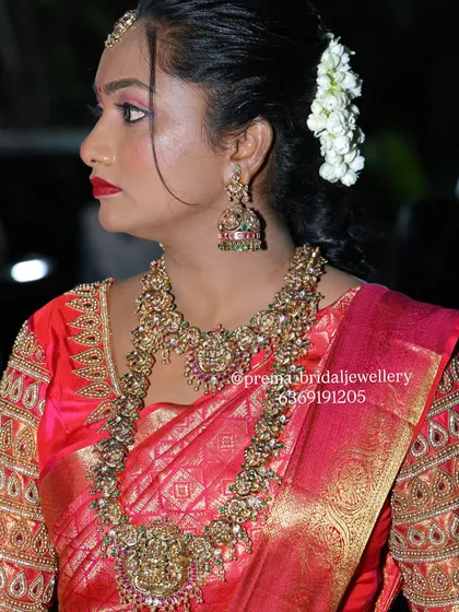 A side profile showcasing the beautiful jhumkas and the detailed work on the long necklace from this antique bridal set.