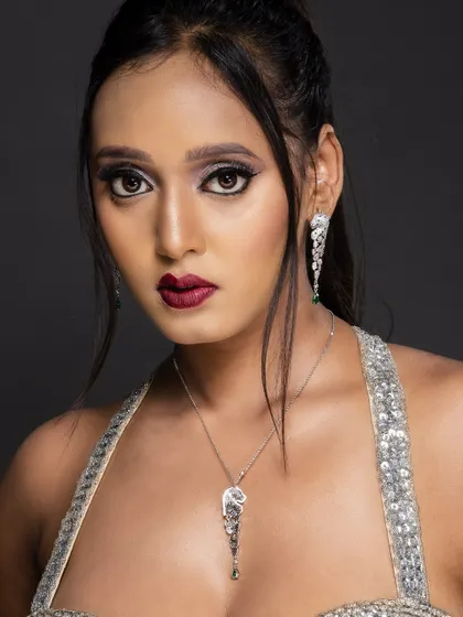 A direct and powerful close-up portrait, showing the full impact of the dramatic eye makeup and bold lip color.