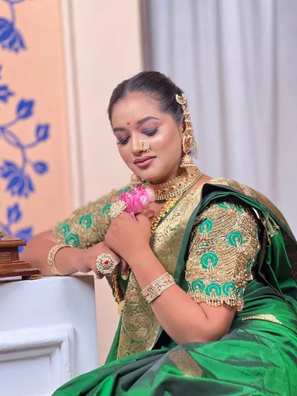 The model posing with a lotus flower, adding a touch of serenity to the traditional 'Rani' look.