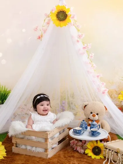 This adorable four-month-old baby girl is all giggles and cuteness in our sunny, sunflower-themed tent setup.