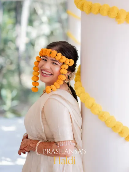 A beautiful portrait of the bride, her face lit up with a huge smile, during her Haldi ceremony.