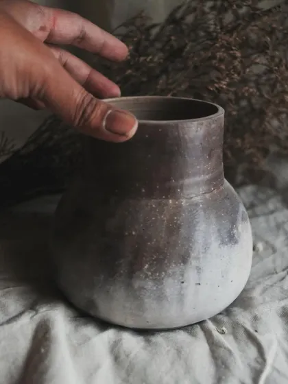 I call this pit-fired vase 'Stardust'. I achieved this subtle, speckled effect by throwing sawdust onto the piece when it was still hot from the fire. It’s a beautiful, earthy piece for dry arrangements.