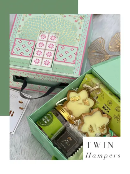 A closer look at our mint green twin hampers. The top drawer holds assorted chocolates, while the bottom is filled with gourmet treats like pistachio roca, trail mix, and gold-leafed cookies.