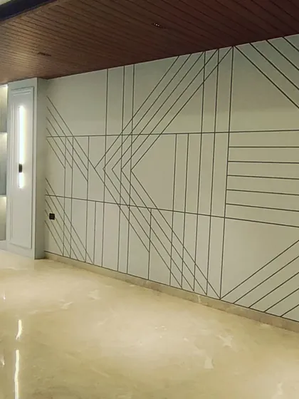 Another example of detailed wall paneling work in an unfurnished space. The clean lines and geometric patterns on the wall are installed, and the polished marble floor is complete.