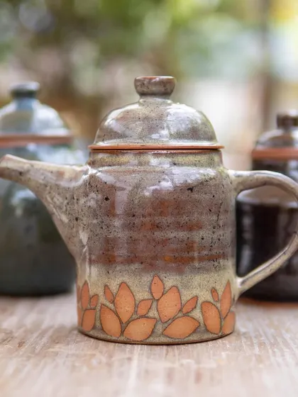 A beautiful teapot featuring intricate surface decoration. Our workshops often integrate multiple skills, allowing students to combine form with techniques like carving and underglazing.