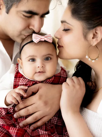 A tender moment between parents and their baby girl. The kisses from both mom and dad show the immense love surrounding this little one.