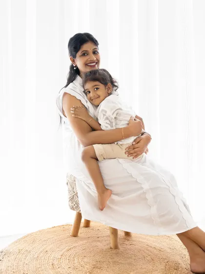 A sweet mother-daughter hug. The all-white outfits and bright background create a fresh and airy feel.
