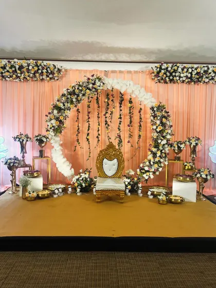 The full stage with the peach and purple floral ring, ready for the celebration. The lighting and symmetrical arrangement create a grand yet inviting atmosphere.