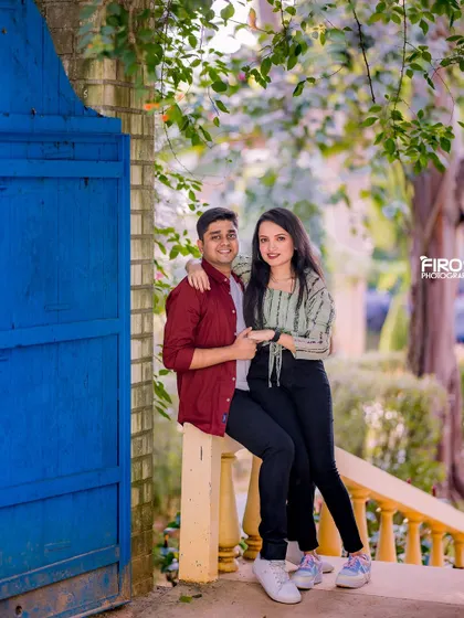 A sweet and relaxed moment on a yellow railing against a bright blue door. This casual portrait captures the easy-going chemistry of the couple.