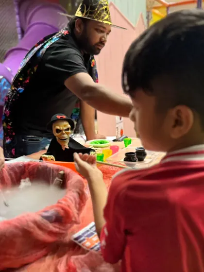 An instructor helps guide the children through the 'spooky fishing' activity, ensuring everyone gets a turn and has a great time.