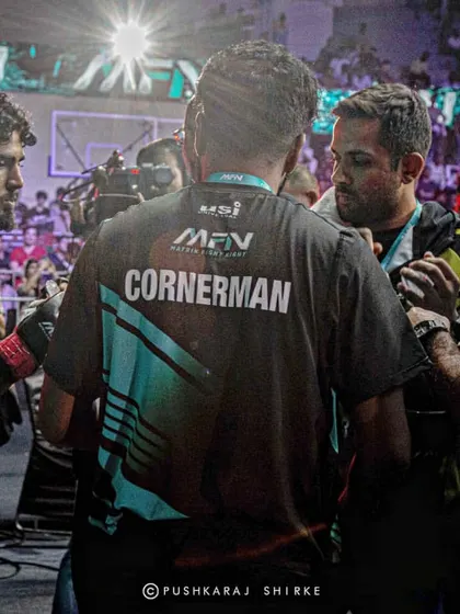 The cornerman's huddle. Strategy is adjusted in these precious seconds between rounds.