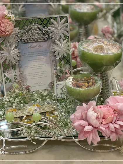 This side view of the pastel green and pink Sagan hamper highlights the elegant silver-plated tray and the careful arrangement of each element, from the frame to the florals.