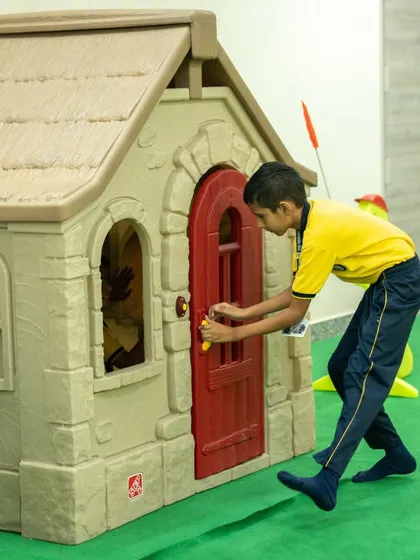 Play is a crucial part of learning. We incorporate elements like this miniature playhouse to encourage imaginative role-playing and social interaction among students in a fun and engaging way.