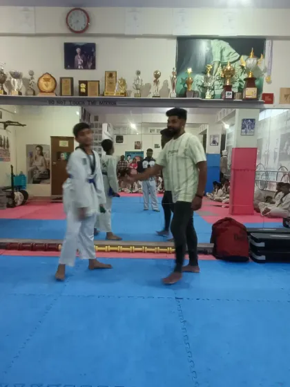 A senior student receives his new belt and a congratulatory handshake.
