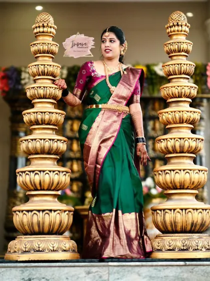 This full-length shot shows the bride standing gracefully. The expert saree draping and coordinated makeup ensure she looks regal and poised.