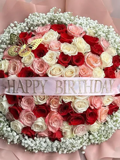 A close-up of our grand birthday bouquet, showing the beautiful texture and color variation of the roses. The golden butterfly accent adds a whimsical touch.