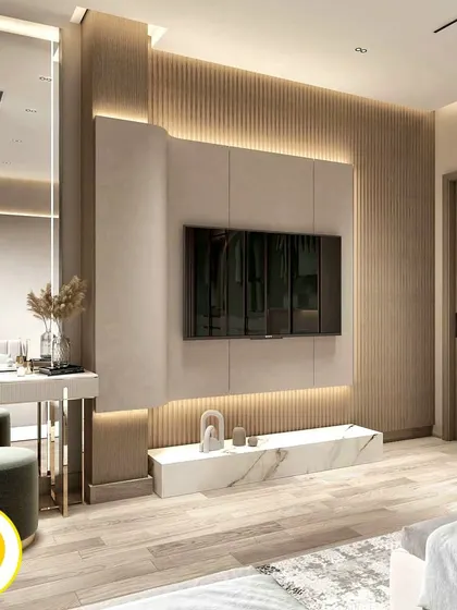 This bedroom features a sophisticated TV and dressing unit. The design combines a fluted wall panel, a large mirror, and a marble-finish console to create a functional and glamorous corner.