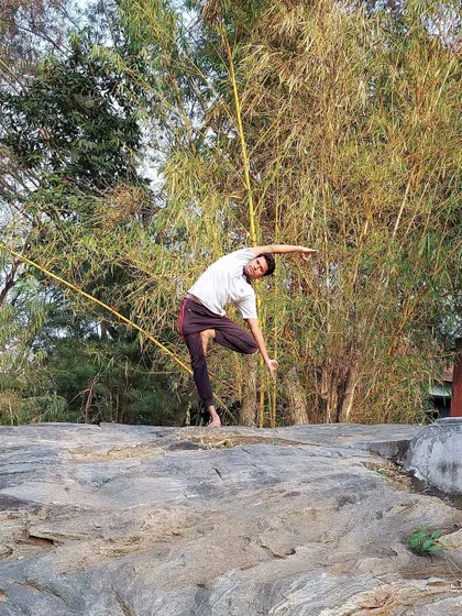 This standing side-bending balance pose, practiced on a rock, increases energy levels by removing blockages along the spinal cord. Practicing in nature enhances this flow of *prana*, leaving you feeling rejuvenated.