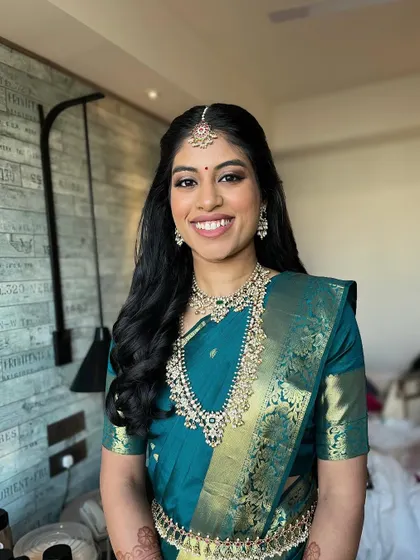 A lovely portrait showcasing the complete look. The makeup, hair, and saree all come together to create a look of timeless South Indian elegance.