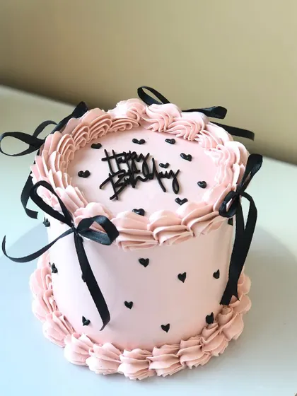 Another version of my vintage-style cake, this time with pink buttercream, black hearts, and black ribbon bows.