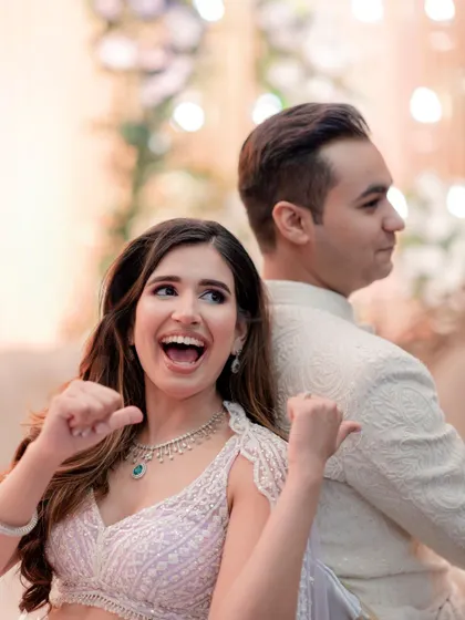 A fun, playful shot from an engagement ceremony, with the bride pointing excitedly at her new ring.