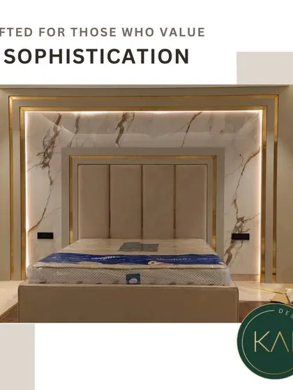 Elevate your bedroom into a luxurious retreat with our integrated design approach. This bespoke bed features a tall, panelled headboard set against a stunning marble wall with backlit gold accents, creating a dramatic and opulent focal point.