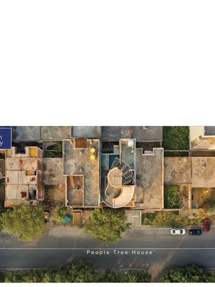 This image, part of an Archdaily feature, provides a wide context of the People Tree House within its neighborhood, highlighting its unique organic form in a grid-planned city.