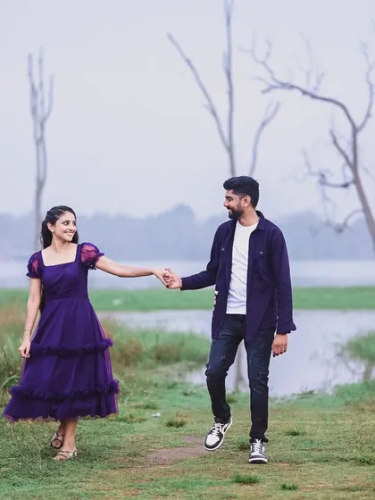 This shot captures a sweet, candid moment between the couple. Her purple dress adds a pop of color to the serene, natural landscape of their pre-wedding shoot.