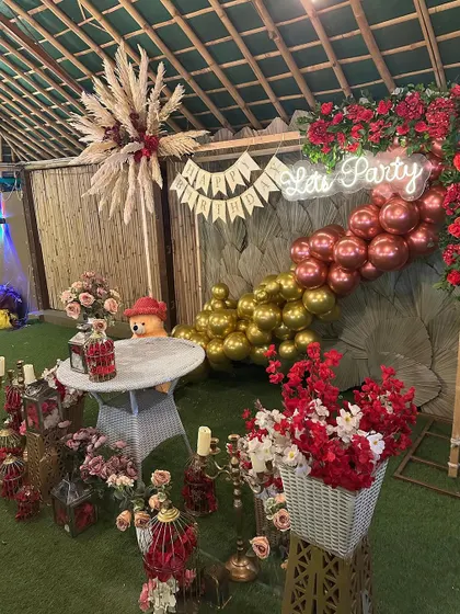 A detailed view of the rustic birthday decor, showcasing the floral arrangements, lanterns, and a cute teddy bear prop that add to the charm.