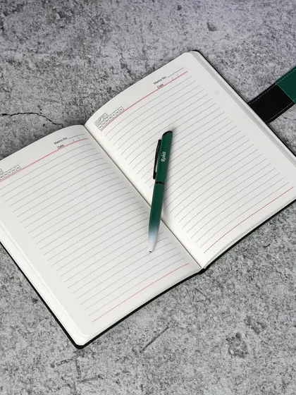 The inside of our custom diaries, showing the high-quality paper and professional layout, paired with a matching engraved pen.