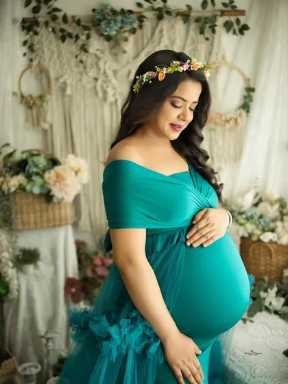 A close-up portrait focusing on the beautiful twin baby bump. The mother-to-be cradles her belly, her expression full of love and wonder.