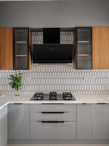 The finished kitchen, with its grey lower cabinets, wood-finish upper cabinets, and stylish picket tile backsplash.