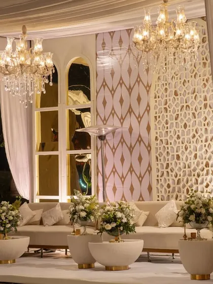 Detail of the luxe lounge seating. I used modern ivory sofas, gold-detailed geometric jaali screens, and arched mirror panels that beautifully reflected the warm glow of the chandeliers.