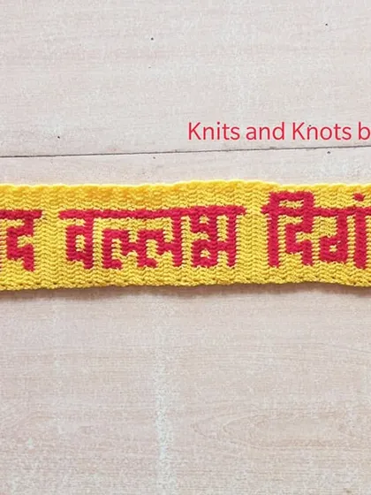A work in progress shot of a "श्रीपाद वल्लभ दिगंबरा" toran, showing the lettering panel before the decorative hangings are attached.