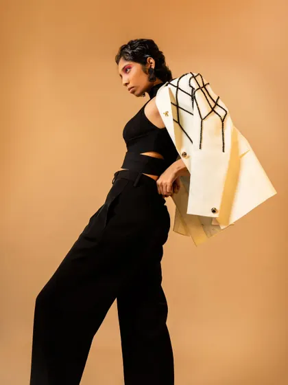 A dynamic pose showing off a modern jacket. The styling and pose create a sense of movement and high fashion.