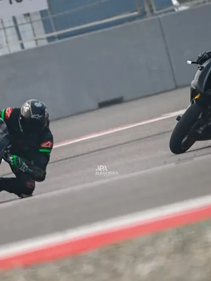 Two riders on all-black sportbikes duel through a corner, demonstrating close but safe racing lines during one of our open sessions.