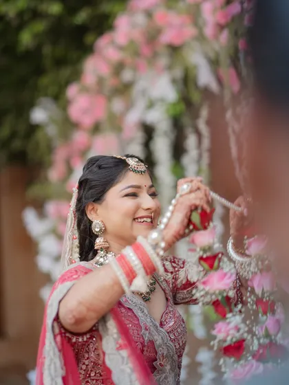 A candid shot of the bride laughing with joy during the Varmala ceremony. These unposed, happy moments are what make your wedding photos truly special and personal.