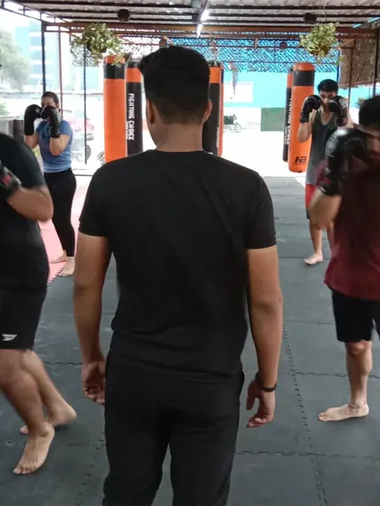 A coach observes and guides members during a group boxing class at our Sector 141 Noida location. Personal attention is key to our training philosophy.