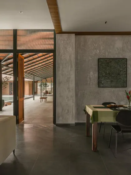 From the dining area, a clear sightline extends through the open doorway to the outdoor courtyard and pool. This visual connection is a key element of the home's open and flowing layout.