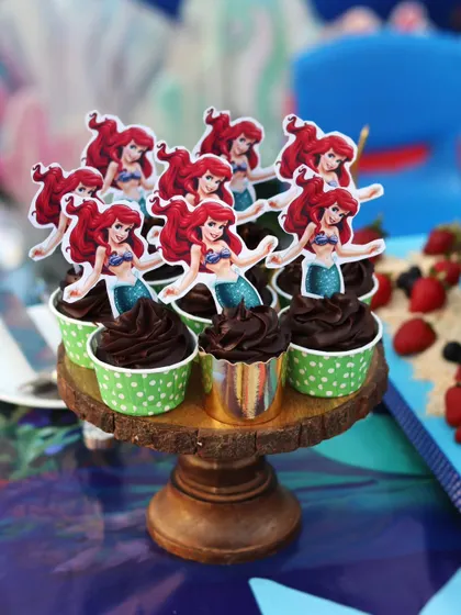 The Ariel cupcakes displayed on a rustic wooden stand.