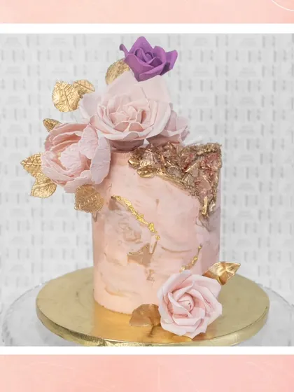 A beautiful pink marble cake with handcrafted sugar flowers and golden petals for a touch of beachside bliss.