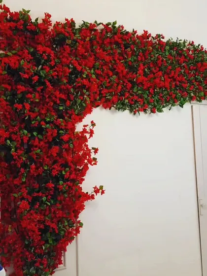 This is a dense garland of artificial red bougainvillea flowers and green leaves. I use these to frame doorways, wrap around pillars, or hang as a festive decoration for parties and events.