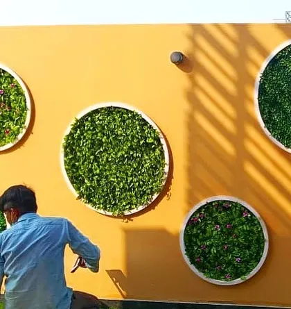 Here you can see me adding the final touches to one of the circular green wall panels, ensuring every leaf is perfectly in place for a full, lush look.