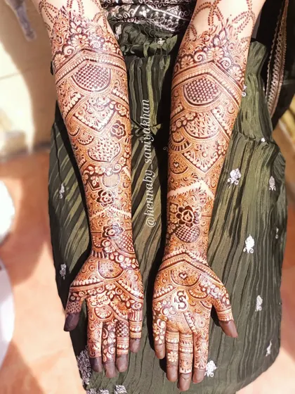 A beautiful sunkissed shot of a bridal mehendi with the initial 'S'.