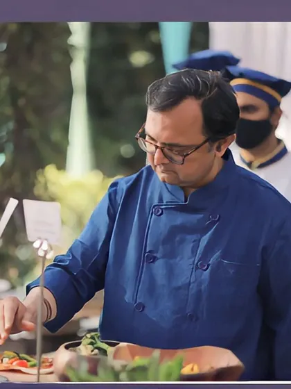 Our head chef personally tends to the buffet, ensuring every dish meets our high standards. Here, he is adding a final touch to a salad at an outdoor wedding lunch.