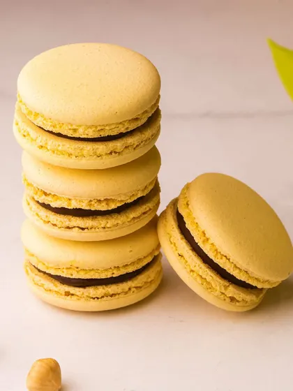 Classic vanilla or hazelnut macarons, with their signature "feet" and smooth shells. They are a testament to the precise technique required to make them perfectly.