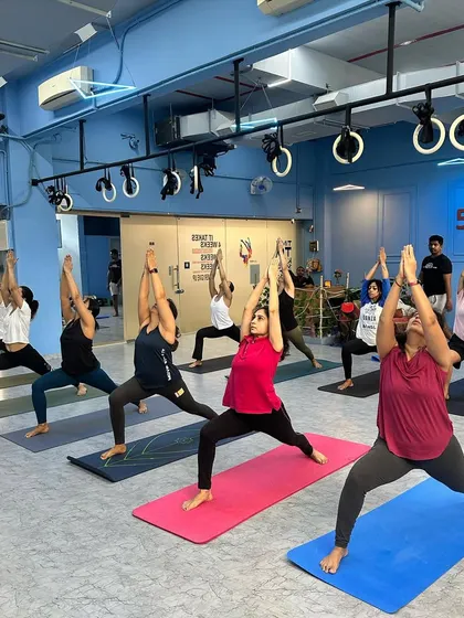 Students in Virabhadrasana I (Warrior I) at our Malad West studio. This class is for regular practitioners and teachers looking to deepen their practice.