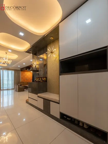 A sophisticated foyer unit with a built-in shoe cabinet and a comfortable seating nook. The design combines white high-gloss finishes with darker tones for a modern, high-contrast look.