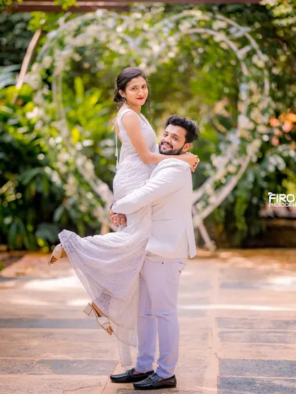 A joyful lift in front of a heart-shaped arch. This shot is full of happiness and perfectly captures the couple's excitement.