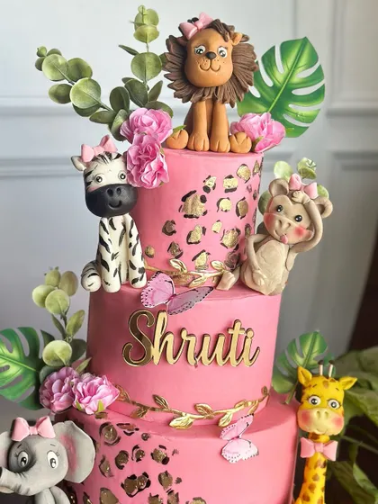 Step into the wild with our pink and gold safari-themed cake. This three-tiered creation is adorned with cute, handcrafted jungle animals and chic leopard print details for a stylish adventure.